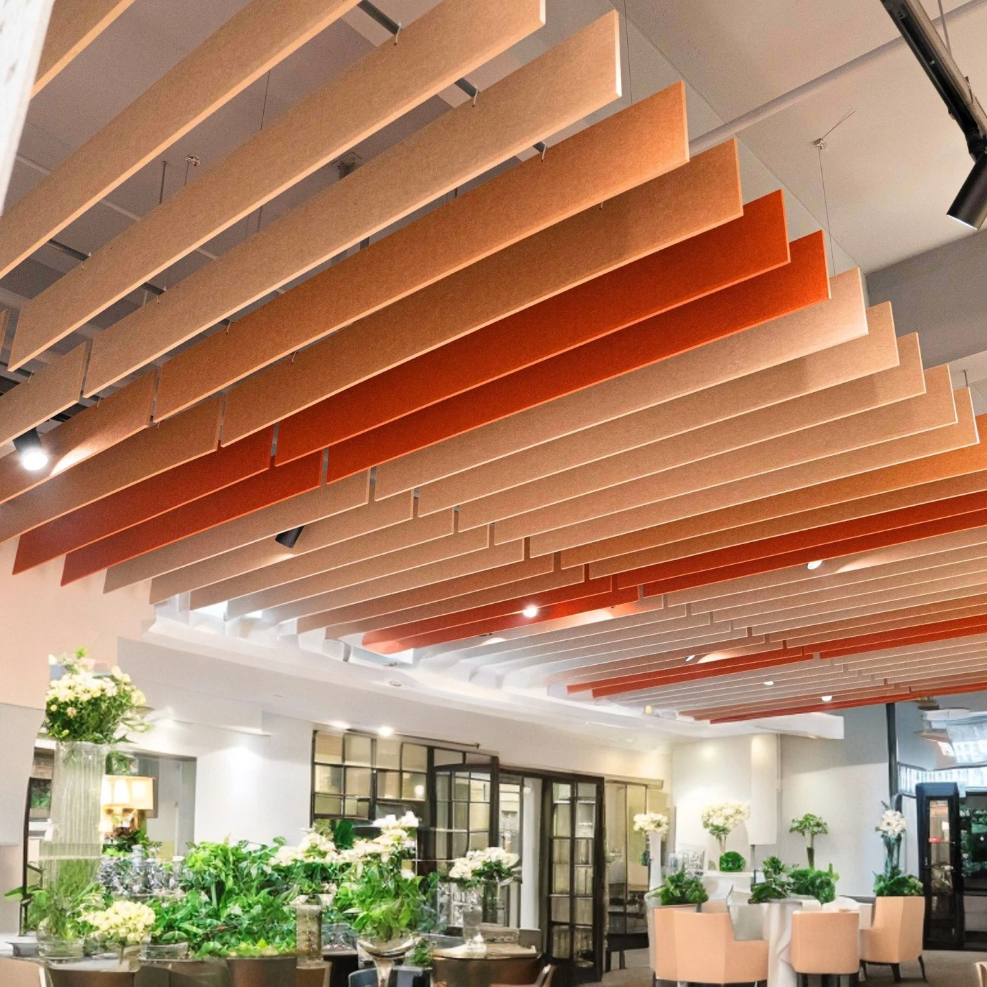 Suspended PET acoustic panels in beige and orange tones